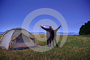 Family traveling and camping, twilight, posing near tent. Beautiful nature - field, forest, stars and moon. Father, son and girl