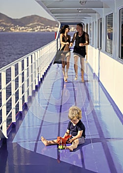 Family travelling on cruise ship, defocused. Family rest concept. Father, mother walk on deck of cruise liner while kid