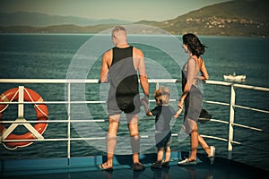 Family travelling on cruise ship on sunny day. Family with cute son on summer vacation. Father, mother and child stand