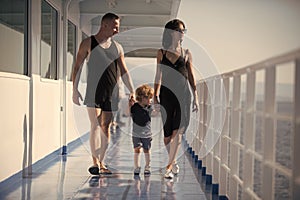 Family travelling on cruise ship on sunny day. Family rest concept. Father, mother and child walk on deck of cruise
