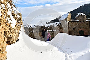 Tourist hiking in the ruins castle on the snow in Slovakia Zborov ruins