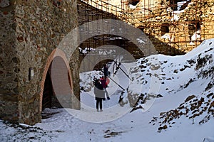 Tourist hiking in the ruins castle on the snow in Slovakia Zborov ruins