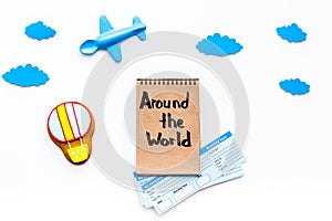 Family trip concept. Airplan toy, air balloon cookie, airplan tickets. Around the world hand lettering in notebook on