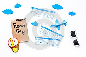 Family trip concept. Airplan toy, air balloon cookie, airplan tickets. Road trip hand lettering in notebook on white