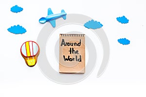 Family trip concept. Airplan toy, air balloon cookie. Around the world hand lettering in notebook on white background
