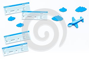 Family trip concept. Airplan toy, clouds, airplan tickets on white background top view copy space