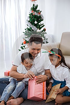 Family try to open their christmas gift together