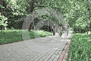 Family with two children on a bike ride in the city Park