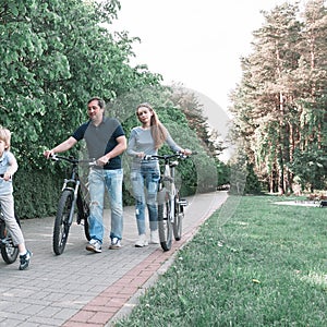 Family with two children on a bike ride in the city Park