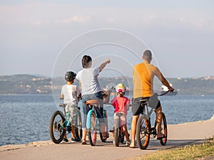 Family with two children on bikes, standing near the sea