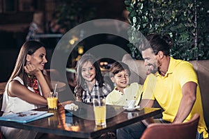 Family with two children having great time in a cafe after shopping