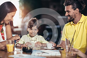 Family with two children having great time in a cafe after shop