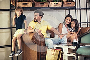 Family with two children having great time in a cafe after shopping