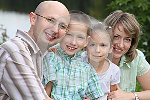 Family with two children in park near pond