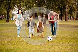 Family with two children playing football together in an