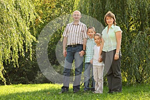 Family with two children is standing near osier