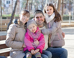 Family with two girls outdoors in sunny fall day