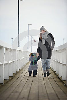 A family of two is walking on a pier