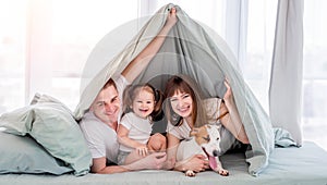 Family under the blanket in the bed