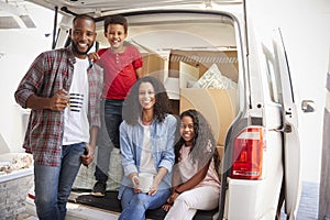 Family Unloading Boxes From Removal Truck On Moving Day