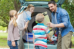 Family unloading car trunk while on picnic