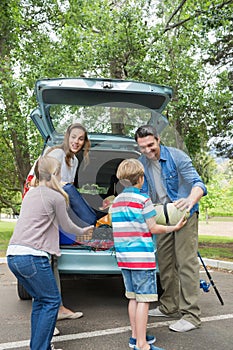 Family unloading car trunk while on picnic