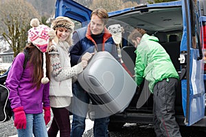 Family Unloading Luggage From Transfer Van