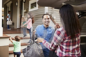 Family Unloading Shopping Bags From Car