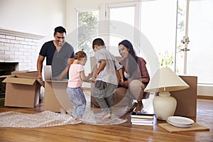 Family Unpacking Boxes In New Home On Moving Day