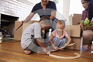 Family Unpacking Boxes In New Home On Moving Day