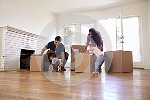 Family Unpacking Boxes In New Home On Moving Day