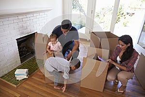 Family Unpacking Boxes In New Home On Moving Day