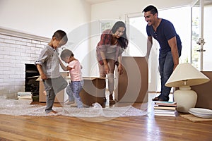 Family Unpacking Boxes In New Home On Moving Day