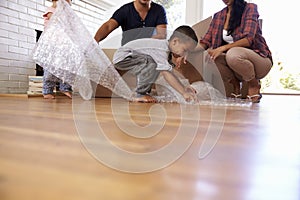 Family Unpacking Boxes In New Home On Moving Day