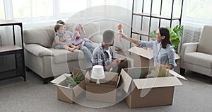 Family unpacking carton box in new house