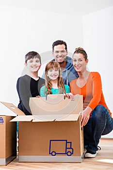 Family unpacking moving boxes in new home