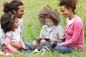 Family Using Digital Tablet Whilst Hiking In Countryside