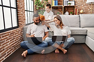 Family using laptop and kid bothering their parents at home