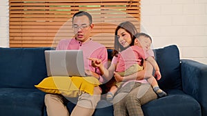 Family using laptop playing together in living room