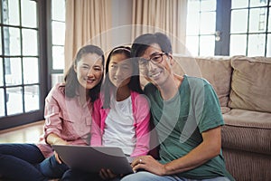 Family using laptop together in living room