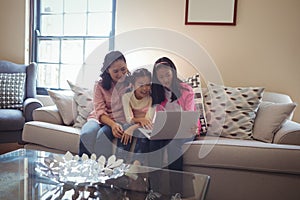 Family using laptop together in living room