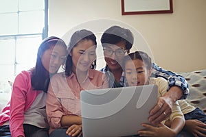 Family using laptop together in living room