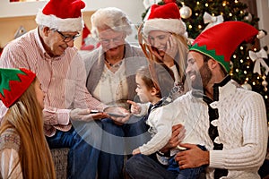 Family using tablet, spending Christmas time together