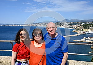 Family on vacation, in background Port of Nice also called  Lympia Port with a large white tourboat