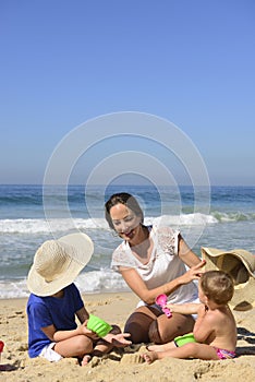 Family vacation on beach: Mother and kids