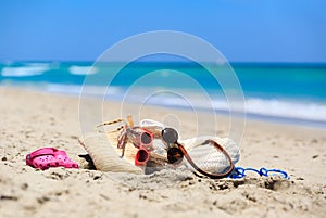 Family vacation concept - bag, suncream, sandals on beach