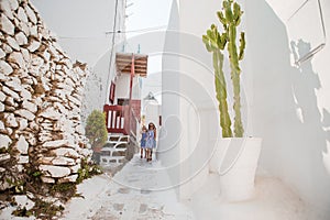 Family vacation in Europe. Father and kids at street of typical greek traditional village on Mykonos Island, in Greece
