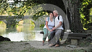 family vacation, happy male and female pensioners enjoying their vacation and relaxing on benches in park on warm day