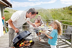 Family on vacation having barbecue photo