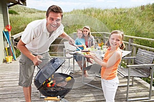 Rodina na dovolenku s barbecue na pláži.